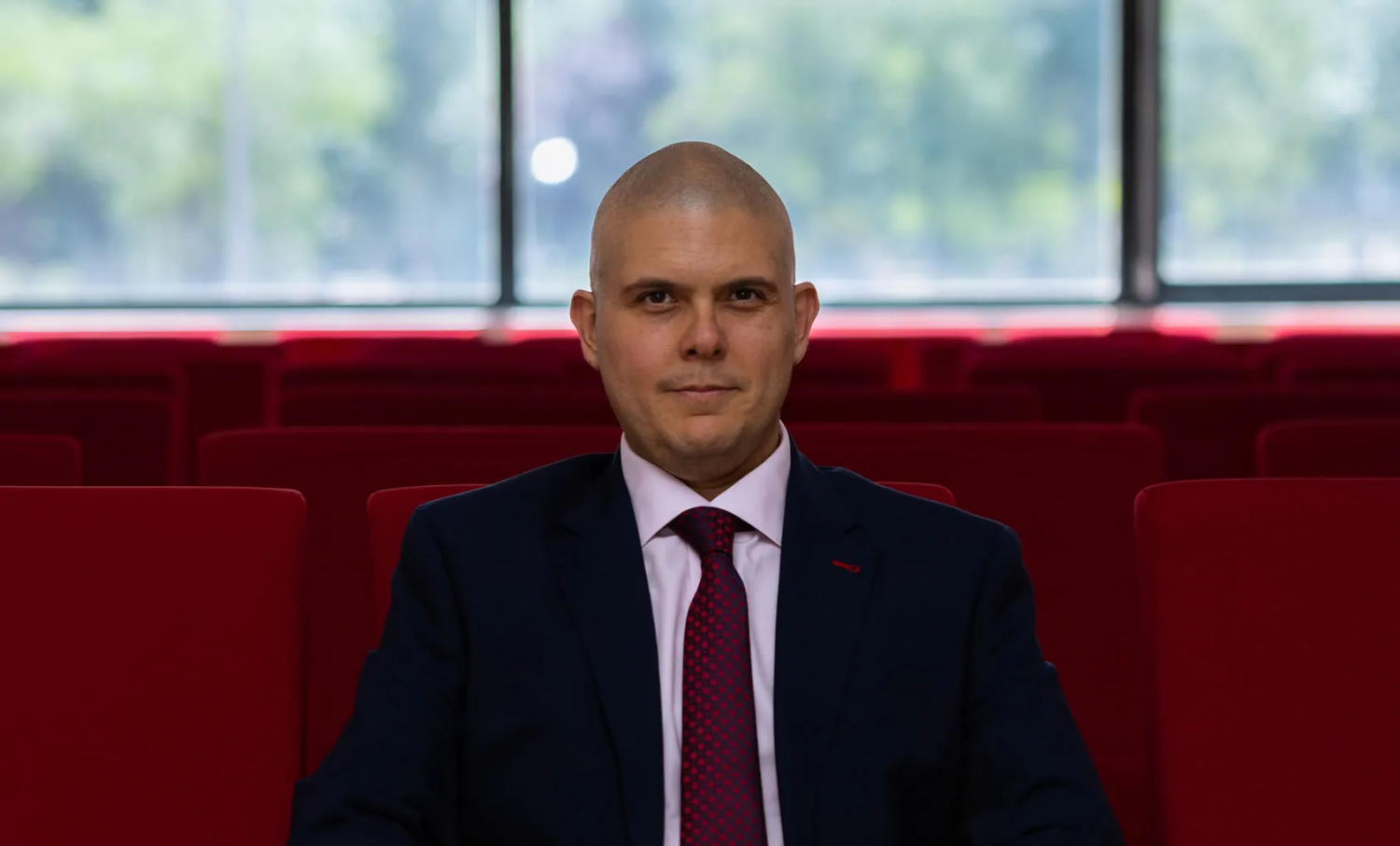 Luis M. Romero-Rodriguez sentado en unas sillas rojas